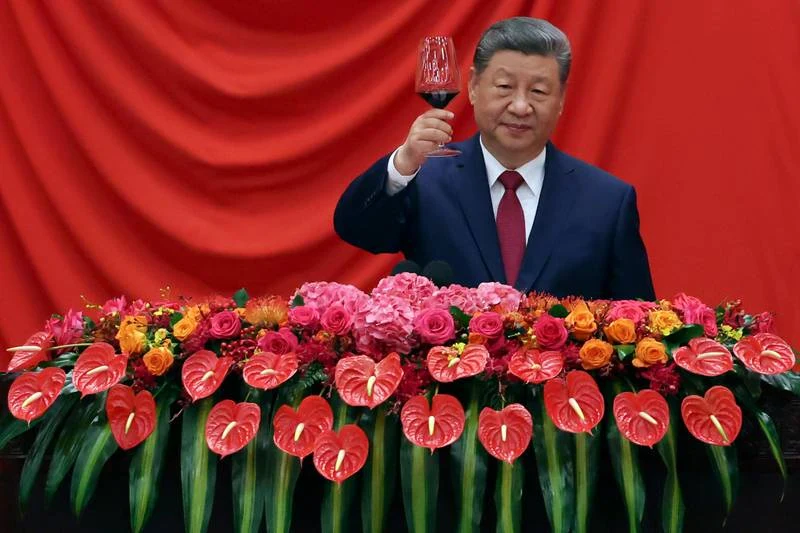 Original photograph of Xi Jinping raising a glass behind a floral display.